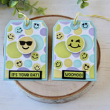 Two handmade greeting tags with smiley faces on each of them.