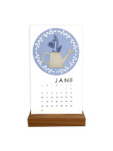 Handmade calendar with a flower in a vase on it with a wreath wrapped around it.