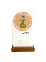 Handmade calendar with a flower in a vase on it with a wreath wrapped around it.