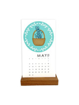 Handmade calendar with a flower in a vase on it with a wreath wrapped around it.