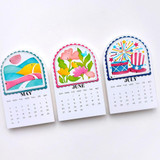 Three handmade calendars with differently month themes on each.