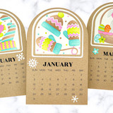 Three handmade calendars with monthly themes on each.