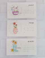 Three handmade calendars with different flowers on each.