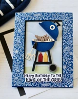 Handmade greeting card with grill on it and hot dogs, condiments, and happy birthday to the king of the grill sentiment on it.