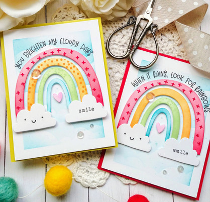 Two handmade greeting cards with rainbows on each .