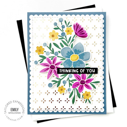 Handmade greeting card of flowers and thinking of you sentiment on it with cardstock in background.