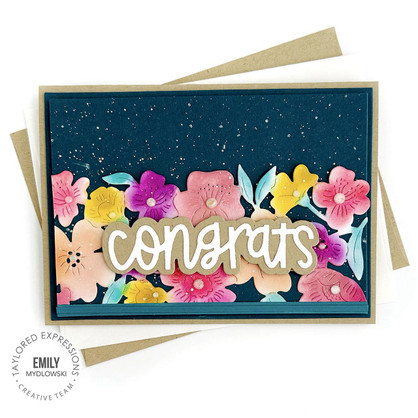 Handmade floral greeting card with congrats sentiment on it with cardstock in background.