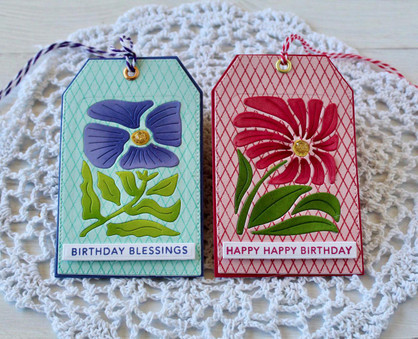 Two handmade greeting tags with flowers on it and one with birthday blessings sentiment and the other with happy happy birthday sentiment on it.