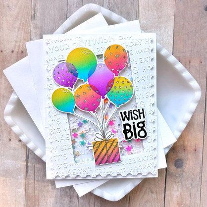 Handmade greeting card with balloons holding a present up and wish big sentiment on it.