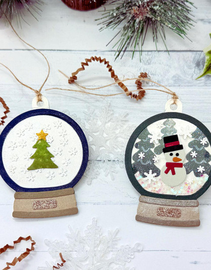 Two handmade gift tags that are snow globe shaped with one having a Christmas tree on it and the other having a snowman on it.