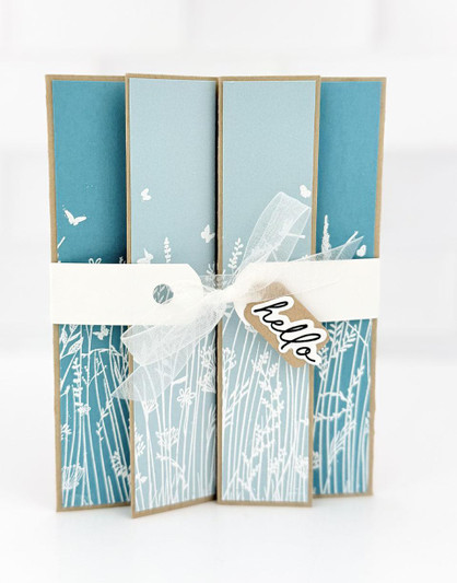 Handmade greeting card with prairie grass on it and hello sentiment on it tied together with a bow.