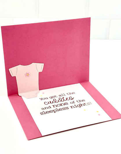Inside of a handmade greeting card with a onesie on it and a baby sentiment on it.