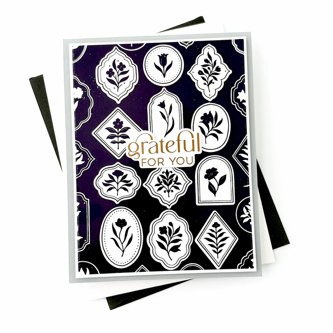 Handmade gratitude card featuring white and purple botanical medallions against a black background with a Grateful sentiment.