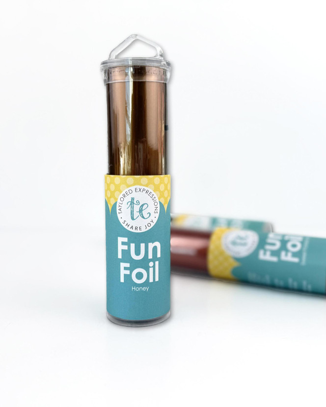 Taylored Expressions TE Fun Foil - Honey metallic golden-brown foil roll in a teal storage tube with a clear cap, displayed against a white background.