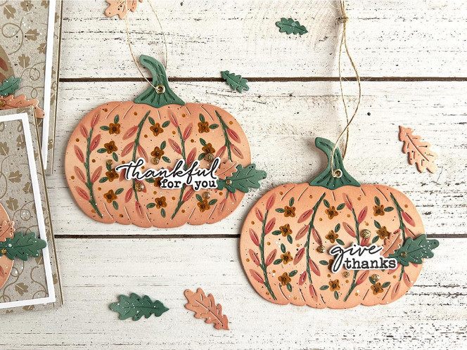 Two handmade pumpkin greeting tags with thankful sentiments on it.