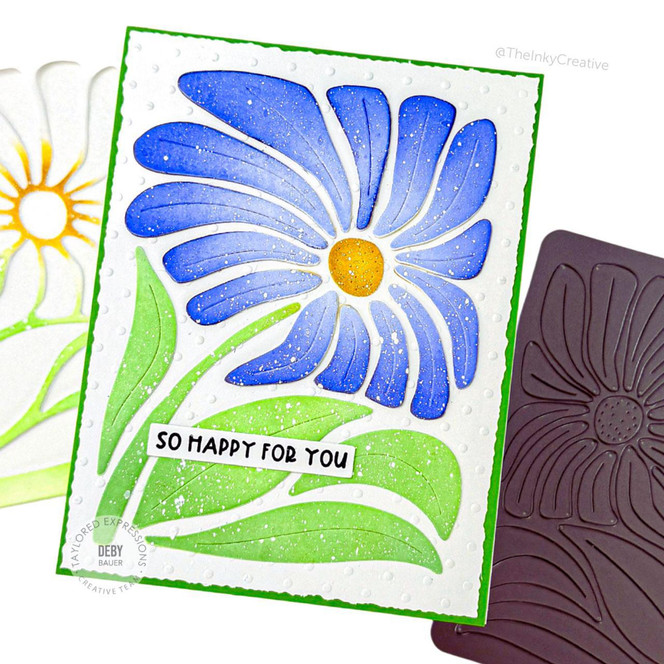 Handmade greeting card with flower on it and so happy for you sentiment on it with crafting materials in background.