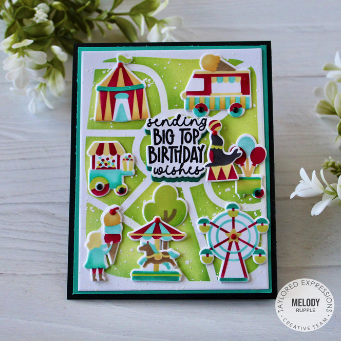 Handmade greeting card that is carnival themed with sending big top birthday wishes sentiment on it with cardstock in background.