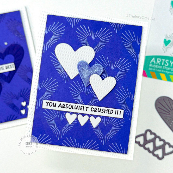 Handmade greeting card with hearts on it and you absolutely crushed it sentiment on it with crafting materials in background.