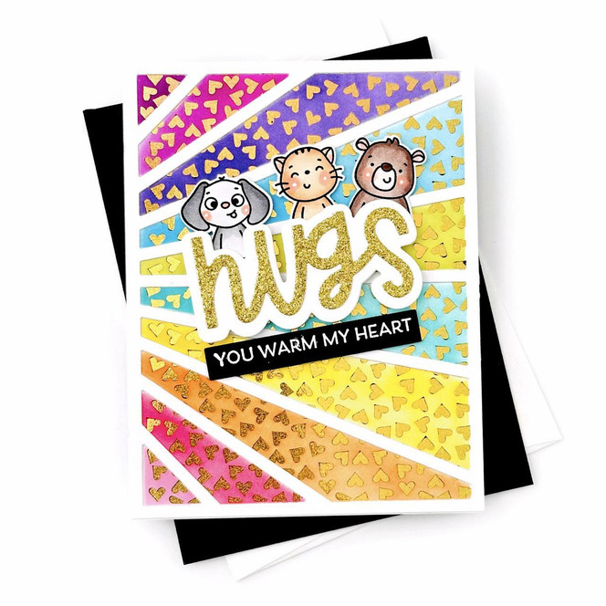 Handmade greeting card with colorful heart rainbow rays and critters on it with hugs you warm my heart sentiments on it with cardstock in background.