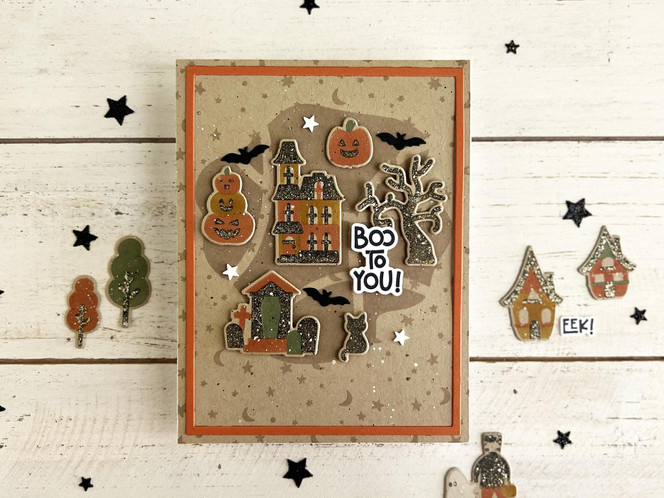 Handmade greeting card with haunted house on it, graveyard, and pumpkins with boo to you sentiment on it.