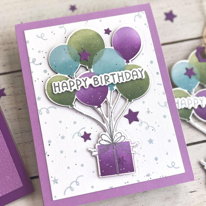 Handmade greeting card with balloons holding a present up with stars in the background and celebrating you sentiment on it.