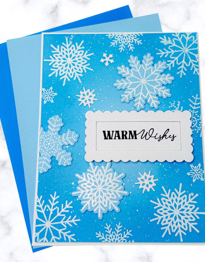Handmade greeting card with snowflakes on it and warm wishes sentiment on it.