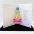 Inside of a handmade greeting card with cake on it and wishing you a birthday piled high with happiness sentiment on it.