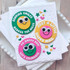 Handmade greeting card with smiley faces on it and various happy sentiments around each smiley face.