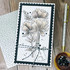 Handmade greeting card with flowers on it and love you sentiment on it with crafting materials in background.
