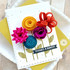 Handmade greeting card with flowers on it and thanks a bunch sentiment on it and cardstock in background.