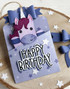 Handmade greeting tag with a unicorn in the pocket of it and happy birthday sentiment on it.