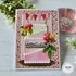 Handmade greeting card with layered cake on it with happy birthday sentiment and sparkles and flowers in the background.