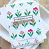 Handmade greeting card with flowers on it and thinking of you sentiment on it with cardstock in background.