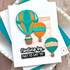 Handmade greeting card with three hot air balloons and floating by just to say hi sentiment on it.