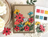 Handmade greeting card with flowers on it and miss you sentiment on it with cardmaking items in background.