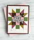 Handmade greeting card with patterned squares on it and happy birthday sentiment on it with cardstock in background.