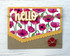 Handmade greeting card with flowers on it and a hello sentiment with a button on it.