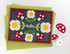Handmade greeting card with mushrooms and flowers on it with hello sentiment and cardstock in background.