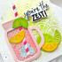 Handmade greeting card with a drink cup, citrus fruit, and you're the zest sentiment on it with cardstock in the background.