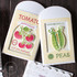 Two handmade greeting card gift holders, one with tomatoes on it and grown with love sentiment and the other with two peas on it with card in the background.