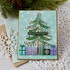 Handmade greeting card with tree with ornaments on it and presents underneath with merry christmas sentiment on it.