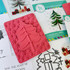 Red rubber stamp included in O Christmas Tree Cardmaking kit that includes a tree cut out with snowflakes in background.