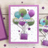 Handmade greeting card with balloons holding a present up with happy birthday sentiment on it.