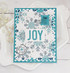Handmade greeting card with snowflakes on it and postage stamps with joy sentiment on it.