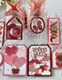 Handmade greeting tags with hearts and various Valentine's themed items on them.