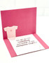 Inside of a handmade greeting card with a onesie on it and a baby sentiment on it.