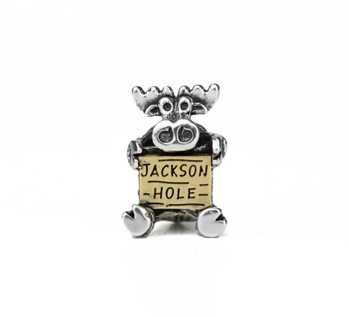This handmade Moose charm in sterling silver holding a 10k yellow gold sign reading "Jackson Hole" is from the locally made Teton Jewelry Collection.