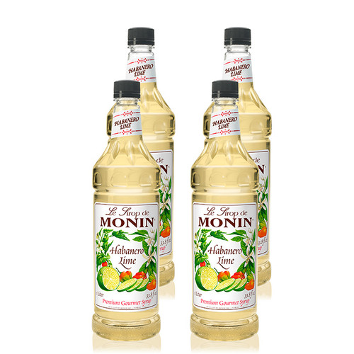 Four bottles of 1-liter (33.8 fl oz) Monin Habanero Lime Premium Gourmet Syrup. The pale yellow syrup is visible through the bottles, which feature a white label with the Monin logo and botanical illustrations of whole and sliced limes, orange habanero peppers, and white lime blossoms. The label includes the text "Habanero Lime" and "Premium Gourmet Syrup."