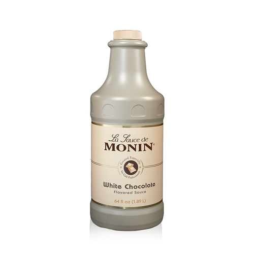 A 1.89-liter (64 fl oz) bottle of Monin White Chocolate Flavored Sauce. The opaque, tan-colored bottle has a matching cream-colored screw cap. The label features the "La Sauce de Monin" logo, an illustration of white chocolate squares, and the text "White Chocolate Flavored Sauce," noting it is "Created Especially for Café Professionals."