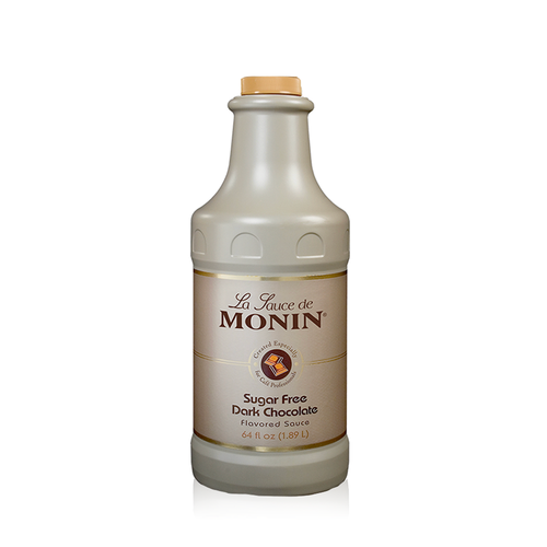 A 1.89-liter (64 fl oz) bottle of Monin Sugar Free Dark Chocolate Flavored Sauce. The opaque, tan-colored bottle has a matching tan screw cap. The label features the "La Sauce de Monin" logo, an illustration of dark chocolate squares, and the text "Sugar Free Dark Chocolate Flavored Sauce," noting it is "Created Especially for Café Professionals."